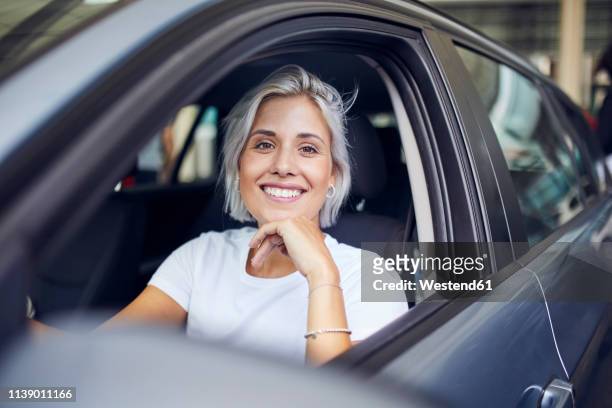 young woman sitting in her car - rijden een motorvoertuig besturen stockfoto's en -beelden