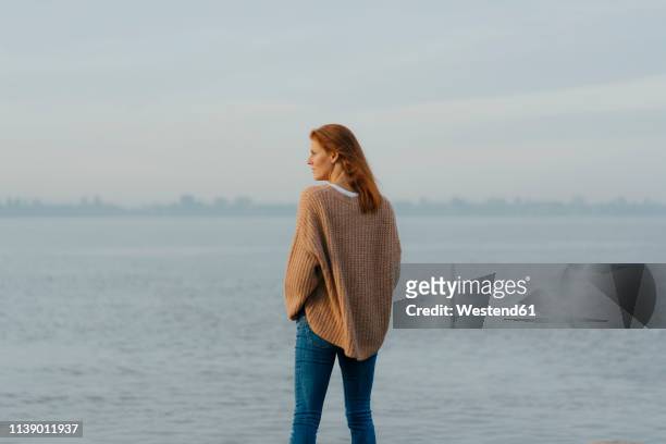 germany, hamburg, woman standing at the elbe shore - looking away stock-fotos und bilder