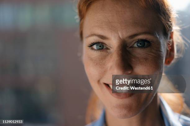 portrait of smiling businesswoman - face sommersprossen stock-fotos und bilder