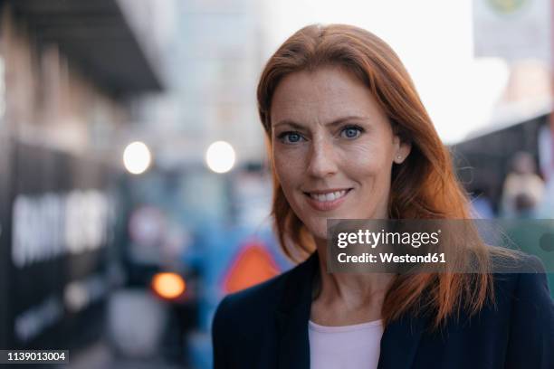 portrait of smiling businesswoman outdoors in the city - blaue augen frau stock-fotos und bilder