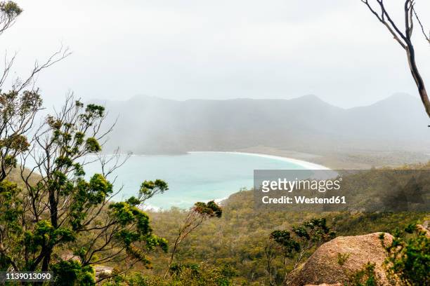 australia, tasmania, freycinet national park, view to wineglass bay on foggy day - wineglass bay stock pictures, royalty-free photos & images