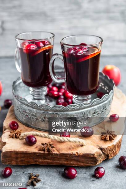 two glasses of mulled wine with cranberries, orange slices and star anise on tray - ホットワイン ストックフォトと画像