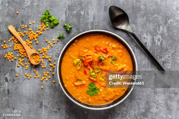 soup bowl of garnished red lentil soup and ingredients - lentil stock-fotos und bilder