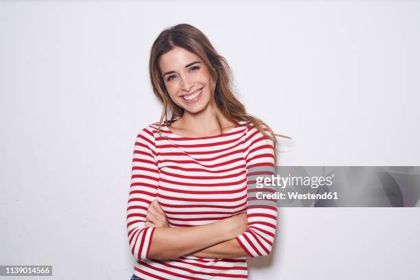 portrait of laughing young woman wearing red-white striped shirt against white background - waist up stock pictures, royalty-free photos & images