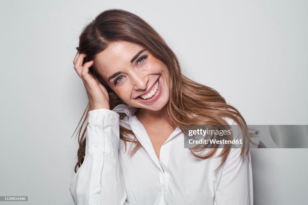 Portrait of laughing young woman wearing white blouse