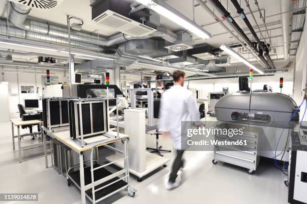 man walking in a factory for manufacturing of circuit boards for the electronics industry - chip fabrik stock-fotos und bilder