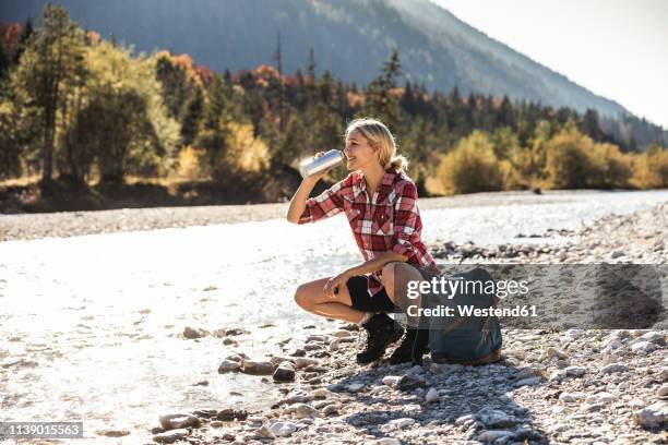 austria, alps, woman on a hiking trip having a break at a brook - hiking woman stock-fotos und bilder