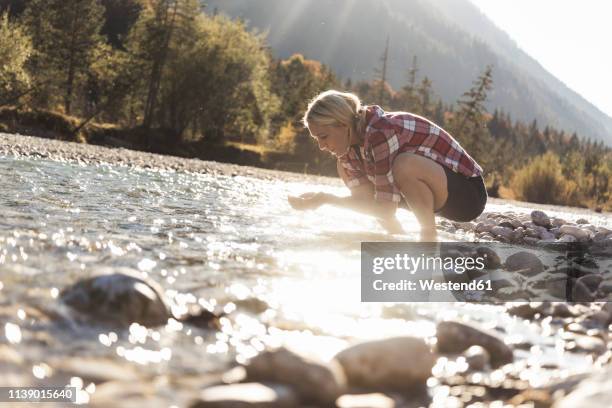 austria, alps, woman on a hiking trip having a break at a brook - ausschöpfen stock-fotos und bilder