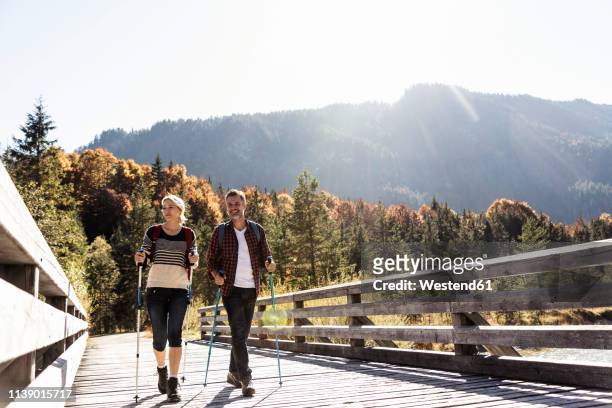 austria, alps, couple on a hiking trip crossing a bridge - cruzar puente fotografías e imágenes de stock