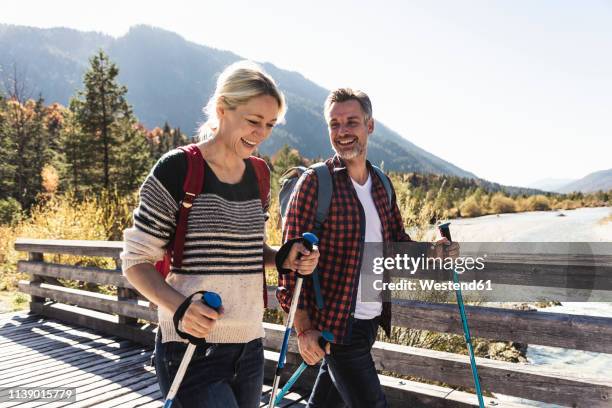 austria, alps, happy couple on a hiking trip crossing a bridge - wandelen lichaamsbeweging stockfoto's en -beelden