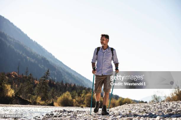 austria, alps, man on a hiking trip walking on pebbles along a brook - nordic walking stock pictures, royalty-free photos & images