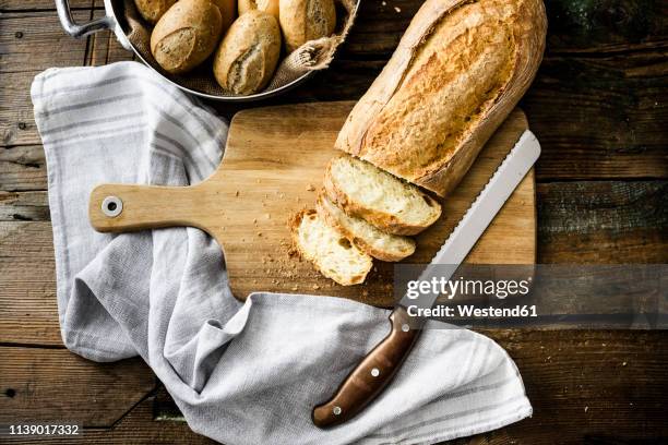 sliced ciabatta on wooden board - bread knife stockfoto's en -beelden