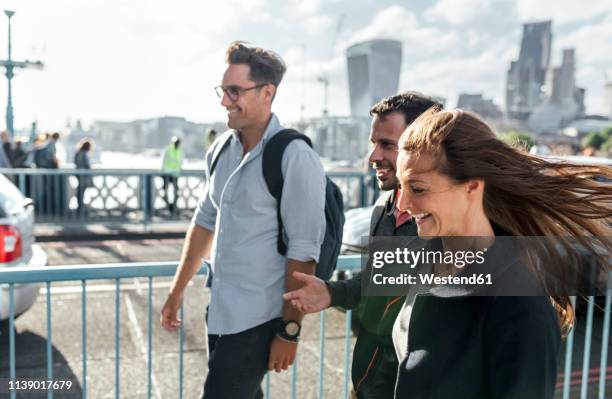 uk, london, happy friends walking on the tower bridge - small group of people outside stock pictures, royalty-free photos & images