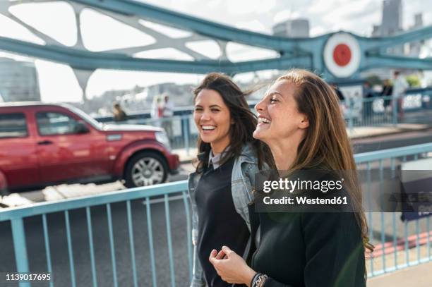 uk, london, two happy women walking on the tower bridge - london 2018 day 2 bildbanksfoton och bilder