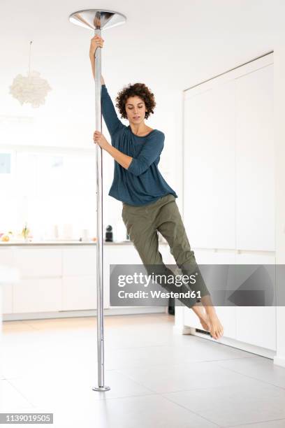 woman doing pole dance at home - pole dance fotografías e imágenes de stock