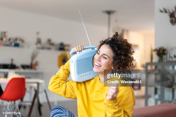 carefree woman listening to music with portable radio at home - portable radio stock pictures, royalty-free photos & images