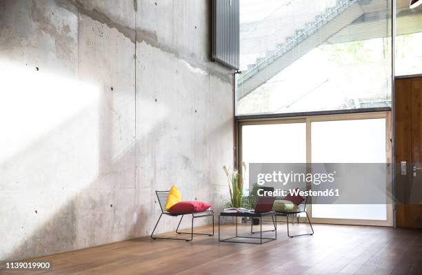 sitting area in a loft at concrete wall - abandoned business stock pictures, royalty-free photos & images