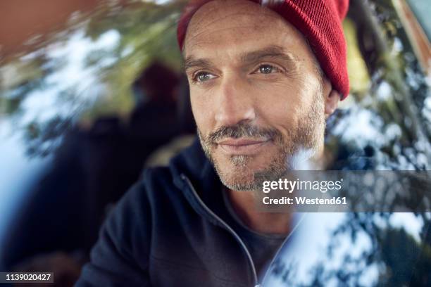 portrait of bearded mature man behind windscreen - auto mann stock-fotos und bilder