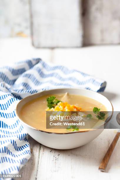 bowl of homemade chicken stock with potatoes, carrots and parsley - hühnersuppe stock-fotos und bilder