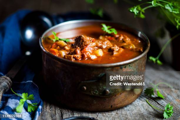 goulash soup with flat leaf parsley - hungarian culture stock-fotos und bilder