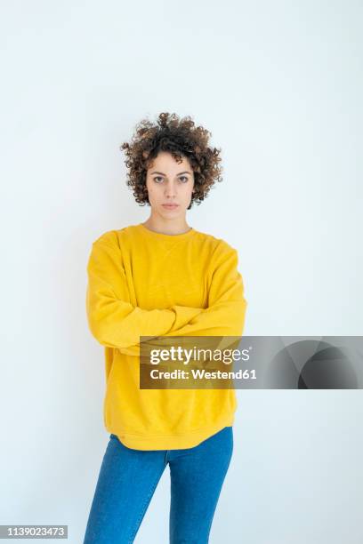 portrait of confident woman wearing yellow sweater - arms crossed woman stock-fotos und bilder