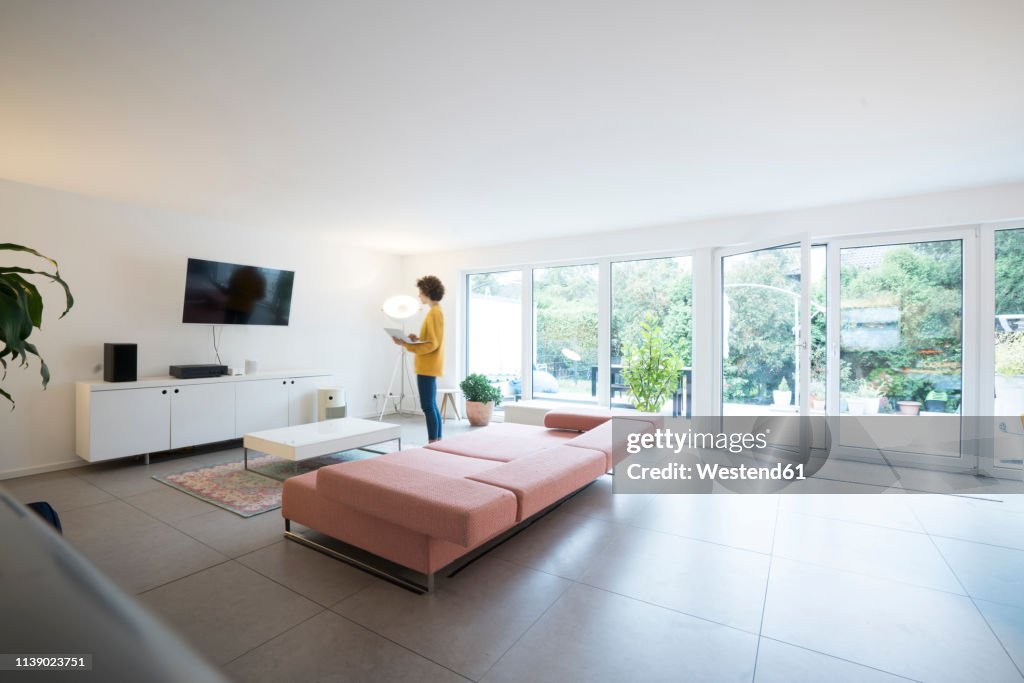 Woman using laptop in a spacious living room at home