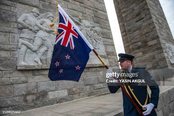 New Zealand soldier holds a flag during an international service marking the 104th anniversary of the WWI battle of Gallipoli at the Turkish memorial...