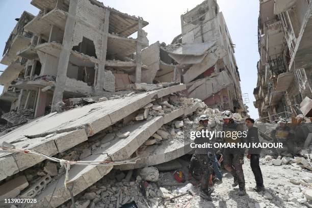 Members of the Syrian Civil Defence, also known as the "White Helmets", search the rubble of a collapsed building following an explosion in the town...