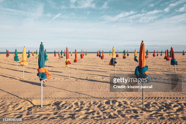 the famous colorful parasols on deauville beach, normandy, northern france, europe - deauville beach stock pictures, royalty-free photos & images