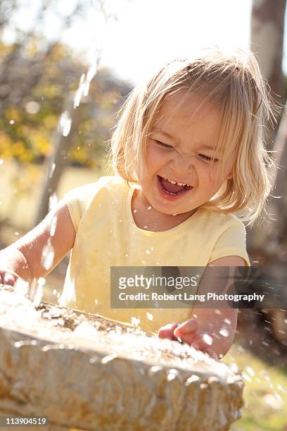 child and splashing water at bird bath - coomunga stock pictures, royalty-free photos & images