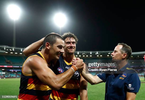 Kyle Hartigan and Taylor Walker of the Crows celebrate with Don Pyke, coach of the Crows, after the round two AFL match between the Sydney Swans and...