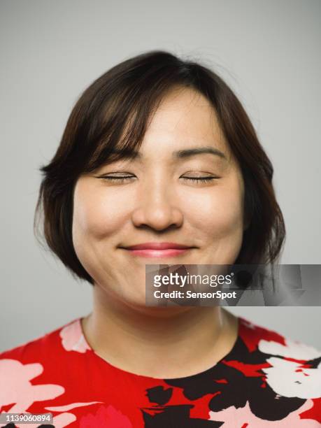 porträt der echten chinesischen reifen frau mit glücklichem ausdruck und geschlossenen augen - character faces asian stock-fotos und bilder