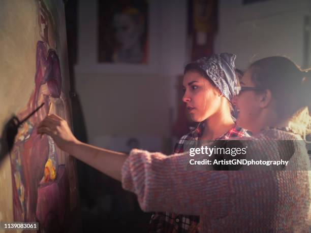 fine art artist and female latino student studying in atelier. - assistant professor stock pictures, royalty-free photos & images