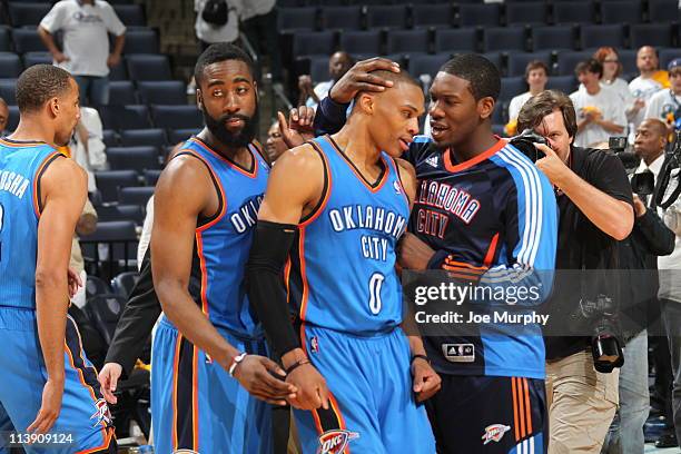 Russell Westbrook of the Oklahoma City Thunder is embraced by teammates James Harden and Royal Ivey after defeating the Memphis Grizzlies in three...