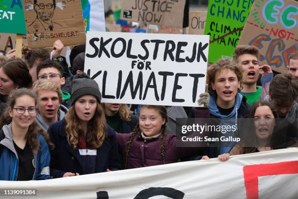 Swedish teenaged climate activist Greta Thunberg holds up her Swedish "School Strike for the Climate" sign as she participates in a Fridays for...