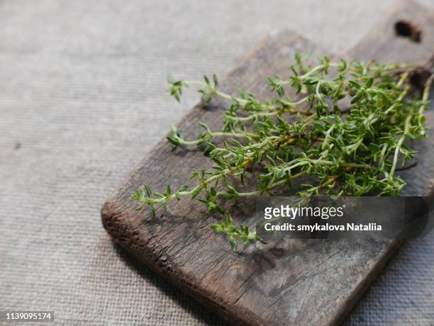 thyme on a wooden chopping board, spice - herb bundle stock pictures, royalty-free photos & images