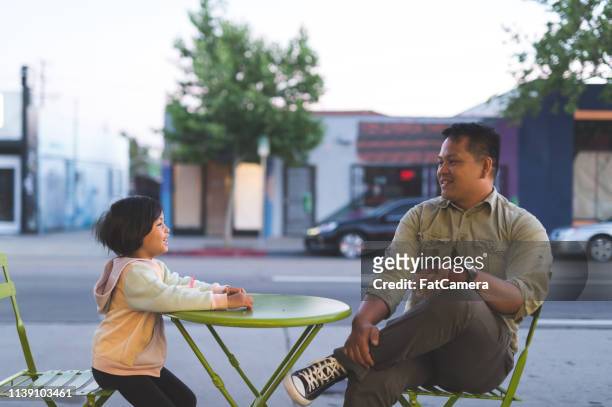 papá y su hija comiendo helado en un café al aire libre - filipino family eating fotografías e imágenes de stock
