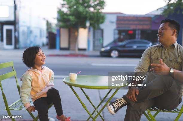 dad and daughter eating ice cream at an outdoor cafe - filipino family eating stock pictures, royalty-free photos & images
