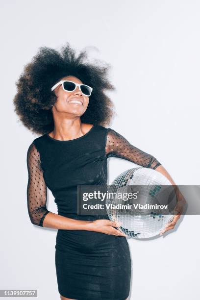 carefree woman in black dress holding disco ball - black dress party stock pictures, royalty-free photos & images