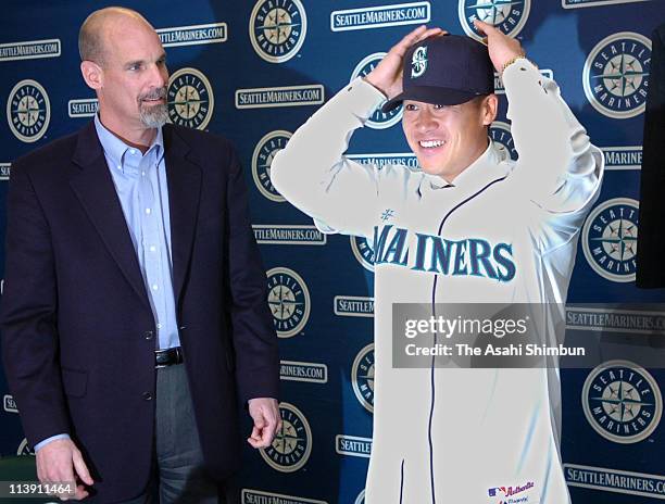 Catcher Kenji Johjima and Seattle Mariners General Manager Bill Bavasi attend a news conference announcing Johjima's signing with the Mariners...