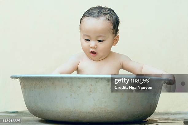 baby enjoys having a bath - washing tub stockfoto's en -beelden