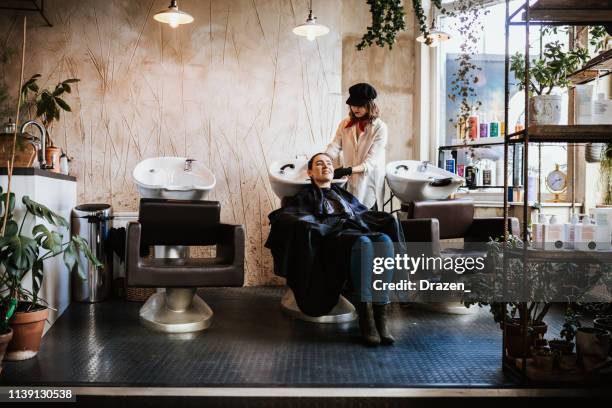 hair washing and rinsing in fancy hair salon - beauty salon stock pictures, royalty-free photos & images