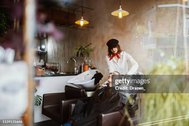 friseur spülen haare, durch das fenster gesehen - ombré hair stock-fotos und bilder