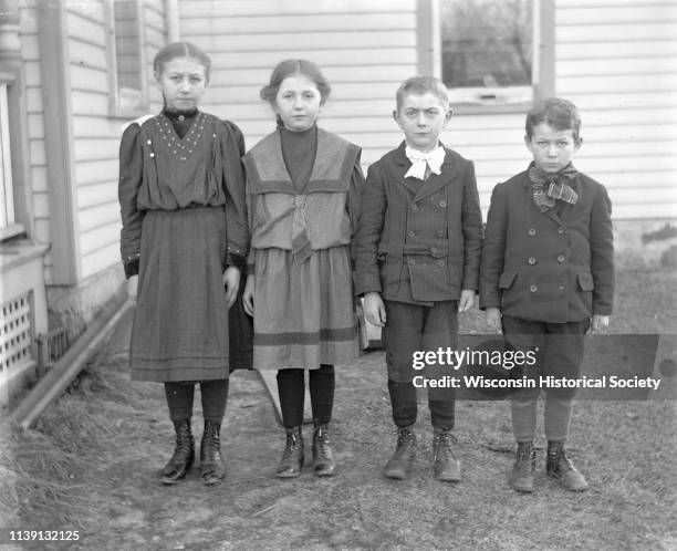 Jennie and Edgar Krueger standing with Clara and Emil Blatter next to a house, Emmet, Wisconsin, January 5, 1907.