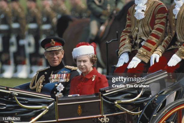 Prince Philip and Queen Elizabeth II, wearing a hat designed by Ian Thomas, travel in a horsedrawn carriage through Berlin while on a State Visit to...