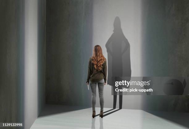 woman standing in with superhero shadow - business hero stock pictures, royalty-free photos & images