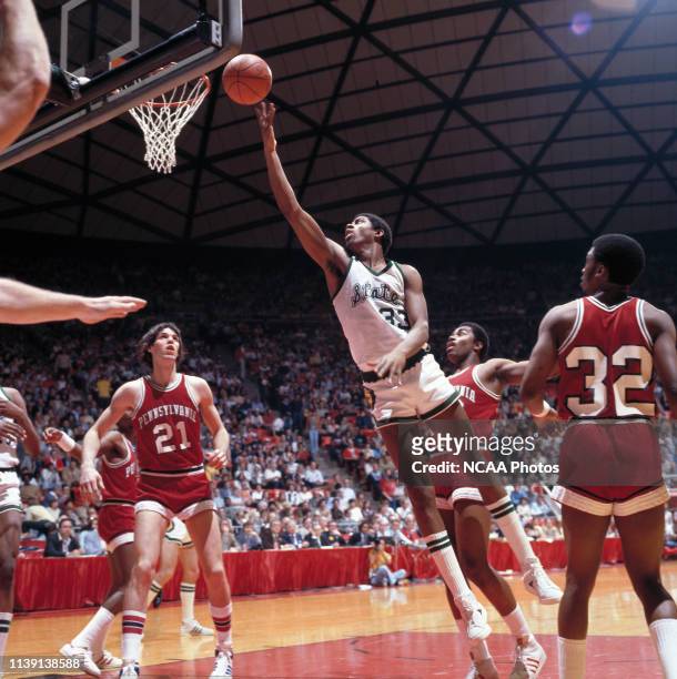 Michigan State guard Earvin “Magic” Johnson lays the ball in as University of Pennsylvania center Matt White and guard Bobby Willis look on during...