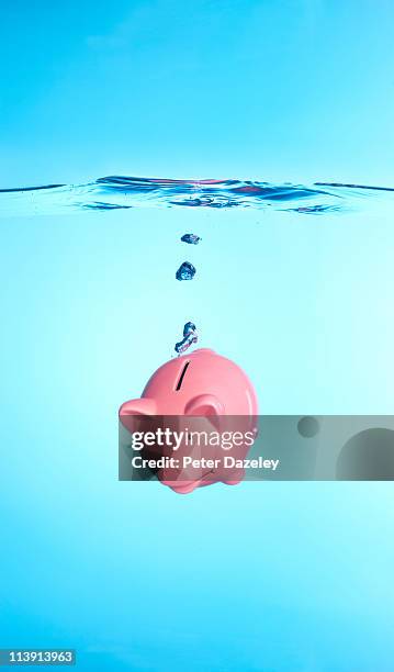 piggy bank sinking in water - drowning stock-fotos und bilder