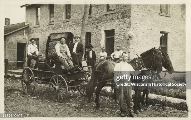 Group of men standing with a horse and wagon, Cross Plains, Wisconsin, 1915. Shown Otto Petersilie, unknown, unknown, unknown, Joseph F Faust,...