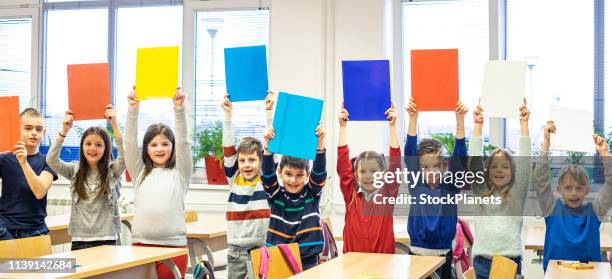 cuadernos multicolor en las manos de los escolares - niño en edad escolar fotografías e imágenes de stock